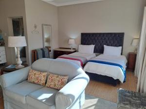 a hotel room with two beds and a couch at Mill Cottages - Rosetta in Rosetta