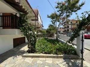 a building with a fence and a yard with flowers at Villa Galini Ierissos in Ierissos