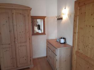 a kitchen with a wooden cabinet and a wooden table at Asbichlerhof in Bad Endorf