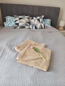 two towels on a bed with a flower on it at Apartament rodzinny 47, 150 m od plaży, basen, plac zabaw, darmowy parking! in Sianozety +25 photos