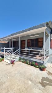 ein Haus mit einer Veranda und Blumen davor in der Unterkunft Seaside House in Paralia Dionisiou