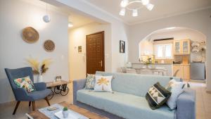 Una sala de estar con un sofá azul y una cocina. en I & G Family Apartment, en Kalambaka