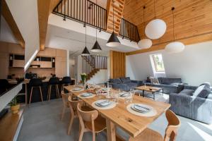 a dining room and living room with a table and chairs at Timber Loft Toplita in Topliţa