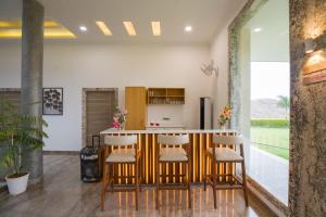 una cocina abierta con encimera y taburetes en ELIVAAS Shourya Celesta Luxe 3BHK Villa with Pvt Pool, Udaipur, en Udaipur