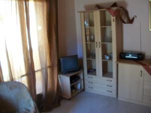 a living room with a television and a book shelf at Alexa Apartment in Corfu