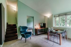 a living room with a staircase and a table and chairs at L'Orangerie di Villa Mayer - MyHomeInComo in Tremezzo