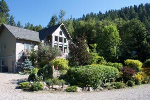 uma casa com um jardim em frente em Windborne Bed & Breakfast em Castlegar