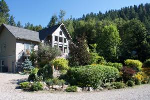 a house with a garden in front of it at Windborne Bed & Breakfast in Castlegar