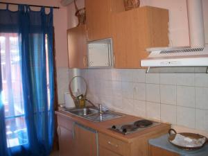 a small kitchen with a sink and a stove at Alexa Apartment in Corfu
