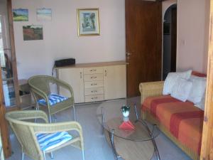 a bedroom with a bed and chairs and a table at Alexa Apartment in Corfu