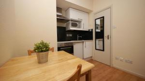 a kitchen with a wooden table with a potted plant on it at Studio 20 Ash in London