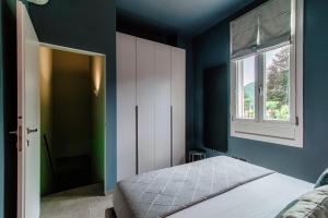 a bedroom with a bed and a window at L'Orangerie di Villa Mayer - MyHomeInComo in Tremezzo +26 photos