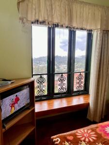 TV a/nebo společenská místnost v ubytování Misty Mountain Kodaikanal