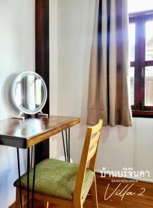 a mirror sitting on top of a wooden table with a chair at V2-Baan Borijinda-Lanna House in The old city of Chiang Mai in Chiang Mai +25 photos