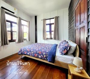 a bedroom with a bed and two windows at V2-Baan Borijinda-Lanna House in The old city of Chiang Mai in Chiang Mai