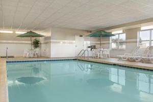una gran piscina con sillas y sombrillas en Country Inn & Suites by Radisson, Peoria North, IL, en Peoria