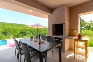 a dining room with a table and chairs and a patio at Villa Manola by Briskva in Labin