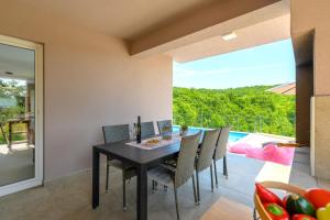 a dining room with a table and chairs and a pool at Villa Manola by Briskva in Labin