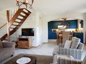 a living room with blue cabinets and a staircase at Buitenplaats 78 in Callantsoog