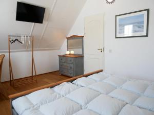 a living room with a bed and a dresser at Buitenplaats 78 in Callantsoog