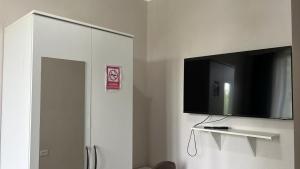 a white cabinet with a flat screen tv on a wall at Hotel T in Bishkek