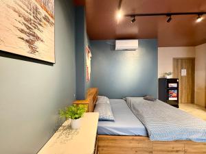 a bedroom with a bed with a blue wall at The Shilla Apartment in Hanoi