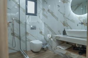 a bathroom with a sink and a toilet and a mirror at Project Georgiadi #2 - Modern Apartment in peaceful neighborhood - 15 mins from Loutra Pozar in Aridaia