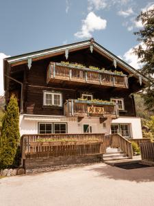 una grande casa in legno con balcone e scale di AURA Bed & Breakfast a Sankt Jakob in Defereggen