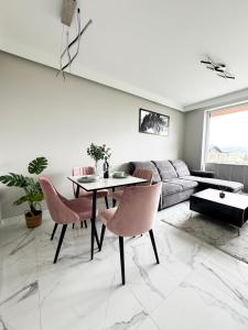 a living room with a table and chairs and a couch at Laguna Beskidów Resort - Apartament A74 in Zarzecze