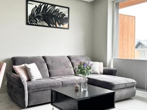 a living room with a couch and a coffee table at Laguna Beskidów Resort - Apartament A74 in Zarzecze