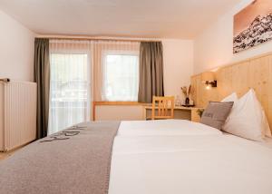 una camera d'albergo con un letto grande e una scrivania di AURA Bed & Breakfast a Sankt Jakob in Defereggen Altre 37 foto