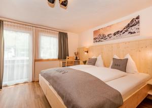 una camera da letto con un letto grande e una finestra di AURA Bed & Breakfast a Sankt Jakob in Defereggen