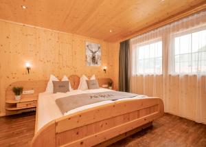 una camera da letto con un letto grande in una stanza con pareti in legno di AURA Bed & Breakfast a Sankt Jakob in Defereggen