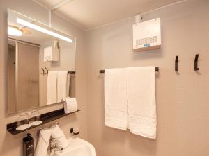 un bagno con lavandino, specchio e asciugamani di AURA Bed & Breakfast a Sankt Jakob in Defereggen