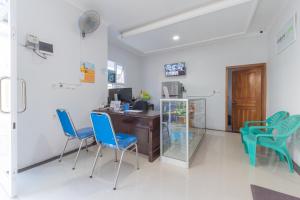 a room with a desk and blue chairs at UrbanView Hotel 3m Syariah in Bandung +14 photos