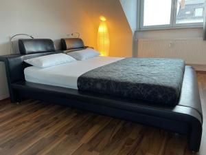 un lit avec un cadre de lit noir dans une chambre dans l'établissement Luxuriöses Zimmer 10min zum Universität Kassel, à Cassel
