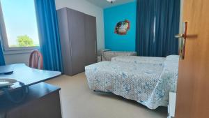 a bedroom with a bed and blue walls and a table at Hotel Ristorante da Toni in Codevigo