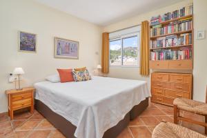 a bedroom with a bed and a book shelf with books at Ap Tesorillo primera línea de playa in Taramay +20 photos