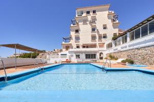 a swimming pool in front of a building at Ap Tesorillo primera línea de playa in Taramay