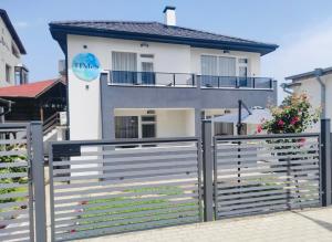 a white house with a fence in front of it at Вила TIMeS in Kiten