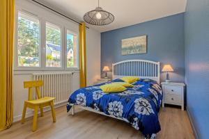a blue bedroom with a bed and a chair at Maison 10 pers 2kms de la plage in Crozon