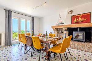 a dining room with a table and chairs and a fireplace at Maison 10 pers 2kms de la plage in Crozon