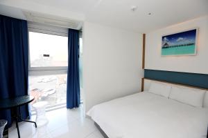 Postel nebo postele na pokoji v ubytování Hamdeok Beach Stay Jeju