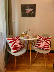 a table with two chairs with a red and white pillow at Final 1room Condo WarszawaCenter in Warsaw