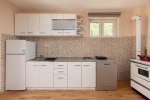 a kitchen with white cabinets and a white refrigerator at Apartman Oasis in Kotor