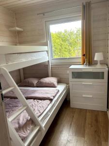 a bedroom with bunk beds and a desk and a window at Słoneczna Gąska in Gąski