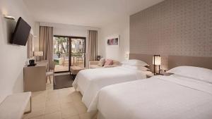 Una habitación de hotel con dos camas y un televisor. en Ona Hacienda del Álamo Golf Resort, en Fuente Alamo