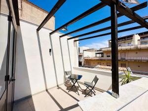a balcony with two chairs and a table on a building at Billy Home in Villabate