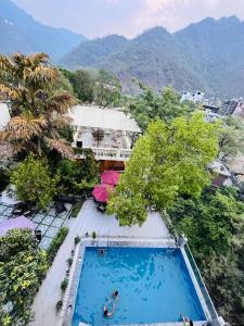 an overhead view of a swimming pool with mountains in the background at Yogved Hospitality & Resort in Rishīkesh