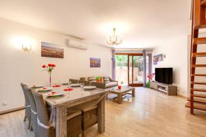 a living room with a dining room table with chairs at Jolie Maison Proche Plage in Toulon
